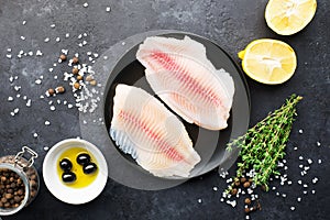 Healthy food ingredients. Fresh sea fish fillet, lemons, spices, salt, herbs, spices for a comfortable diet. Against a