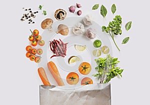 Healthy food ingredients. Fresh vegetables with herbs and spices spilled out of shopping paper bag