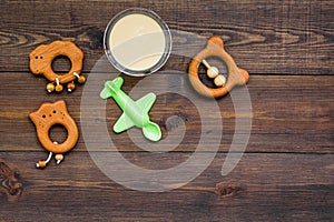 Healthy food for little baby. Puree with near toys on dark wooden background top view copy space