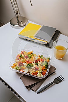 Healthy food in lunch box, on working table with laptop