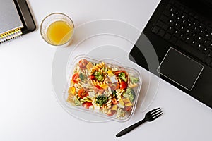 Healthy food in lunch box, on working table with laptop