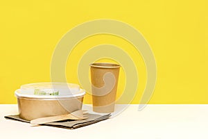 Healthy food lunch in kraft paper carton eco friendly box disposable bowl packaging container, cup on yellow background. chicken,