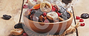 Healthy food: mix from dried fruits in bowl, old wooden background, copy space, banner, selective focus