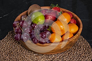 Healthy food: mix from fruits in bowl, old marble background.