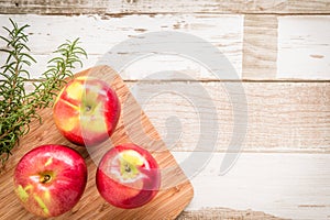 Healthy food: red apples and rosemary on wooden table