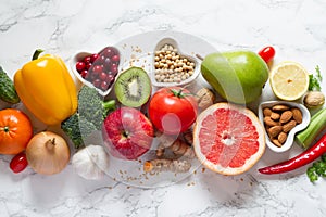 Healthy food selection: fruits, vegetables, seeds, nuts on light background