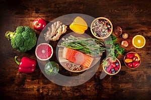 Healthy food, shot from above. Salmon, asparagus, and other superfoods on a dark rustic wooden background