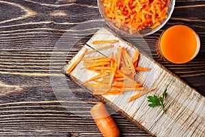 Healthy food - sliced carrot and carrots juice on wooden background