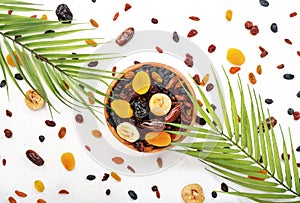 Healthy food snack: natural sun dried fruits mix in bowls on white background, top view