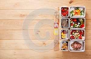 Healthy food take away in boxes, top view at wood