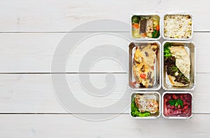 Healthy food take away in boxes, top view at wood