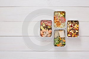 Healthy food take away in boxes, top view at wood