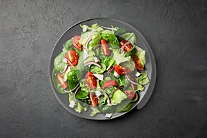 Healthy food. Top view of a fresh green vegetable salad of spinach, tomato, lettuce and sesame seeds