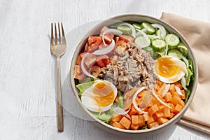 Healthy food tuna salad add egg in white bowl on wood background