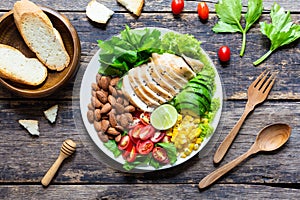 Healthy food, Vegetable salad with chicken and almond in a white plate on wooden table. Top view