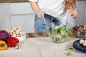 Healthy Food - Vegetable Salad. Diet. Dieting Concept. Cropped image woman preparing vegetable salad in her kitchen