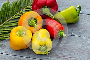 Healthy food vegetarian diet, bell peppers red, yellow and green on wooden blue background, close-up