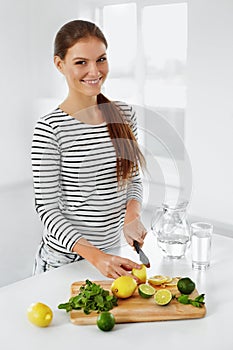 Healthy Food. Woman Cutting Lemons And Limes. Healthy Lifestyle