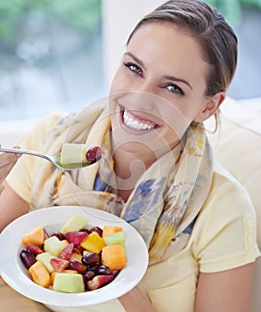 Healthy food, woman in portrait with fruit in salad and diet, organic breakfast and relax on sofa with smile for weight