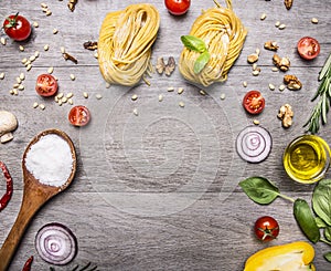 Healthy foods, cooking and vegetarian concept pasta with flour, vegetables, oil and herbs on wooden rustic background top view bor