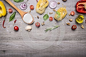 Healthy foods, cooking and vegetarian concept pasta with flour, vegetables, oil and herbs on wooden rustic background top view bor