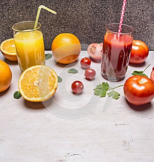 Healthy foods fresh juice in glasses with straws, oranges and tomatoes wooden rustic background top view close up