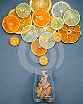 Healthy foods and medicine concept. Bottle of vitamin C and various citrus fruits. Mixed citrus fruits sliced