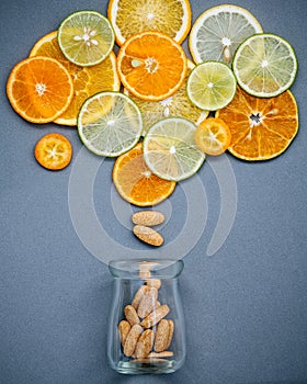 Healthy foods and medicine concept. Bottle of vitamin C and various citrus fruits. Mixed citrus fruits sliced