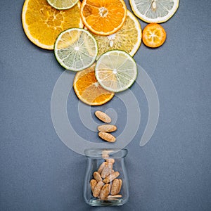 Healthy foods and medicine concept. Bottle of vitamin C and various citrus fruits. Mixed citrus fruits sliced lime,orange and