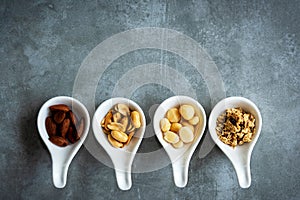 Healthy Foods. Mixed nuts in white bowls with nuts for diet on a concrete table. Different kinds of tasty and healthy nuts. Top vi
