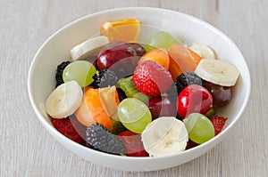 Healthy fresh fruit salad in white plate. Top view.