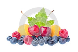 Healthy fresh fruits. Composition of ripe red sweet cherry with horns, raspberries, apricots and blueberries with leaves isolated