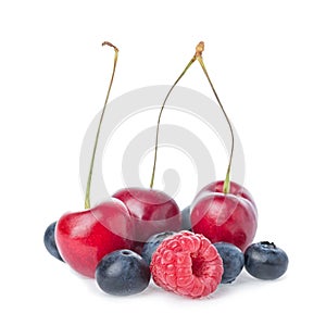 Healthy fresh fruits. Composition of ripe red sweet cherry with horns, raspberry and blueberries isolated on white background