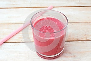 Healthy fresh smoothie drink from raspberries and coconat in glass with straw