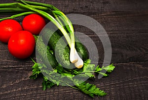 Healthy fresh vegetables on wooden table. Flat lay with chives, tomatoes, parsley, cucumbers.