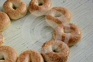 Healthy freshly baked bagels on white wooden background