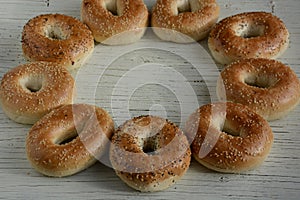Healthy freshly baked bagels on white wooden background