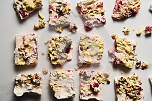 Healthy Frozen Greek Yogurt bars with strawberry with lime zest, nuts and white chocolate. Homemade sweet dessert on