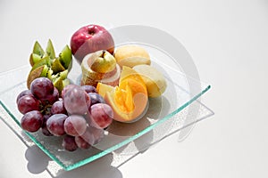 Healthy fruit platter, oranges ,apples ,kiwis, grapes ,pear on the white table, top view, copy space, selective focus