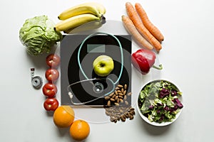 Healthy fruit,vegetables and stethoscope on scales. Weight loss and right nutrition concept photo