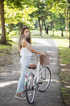 Healthy girl with bicycle in park