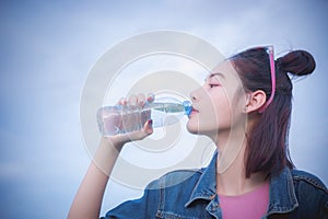 Healthy girl`s drinking water in the bottle , drink for thirstil