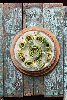 Healthy gluten free, sugar free, no bake dessert. Homemade pie with kiwi roses, berries, mint and cream filling on nutty crust on