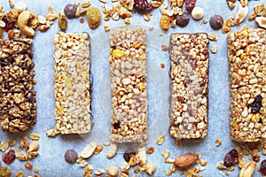 Healthy granola bars with dried fruits, nuts and honey on wooden background.