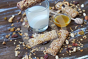 Healthy granola bars with dried fruits, nuts and honey on wooden background.