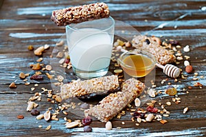 Healthy granola bars with fruits, nuts and honey on wooden background.