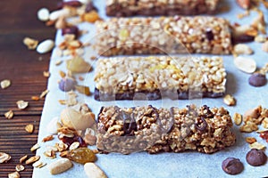 Healthy granola bars with fruits, nuts and honey on wooden background.