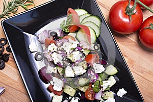 Healthy greek salad on the black plate