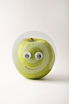 Healthy green apple with face on white isolated background