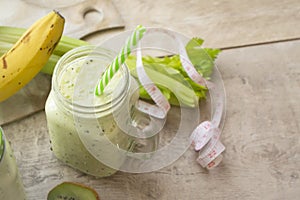 Healthy green juice detox coctail or smoothie with measuring tape. Glass with paper straw. Healthy eating, detoxing photo